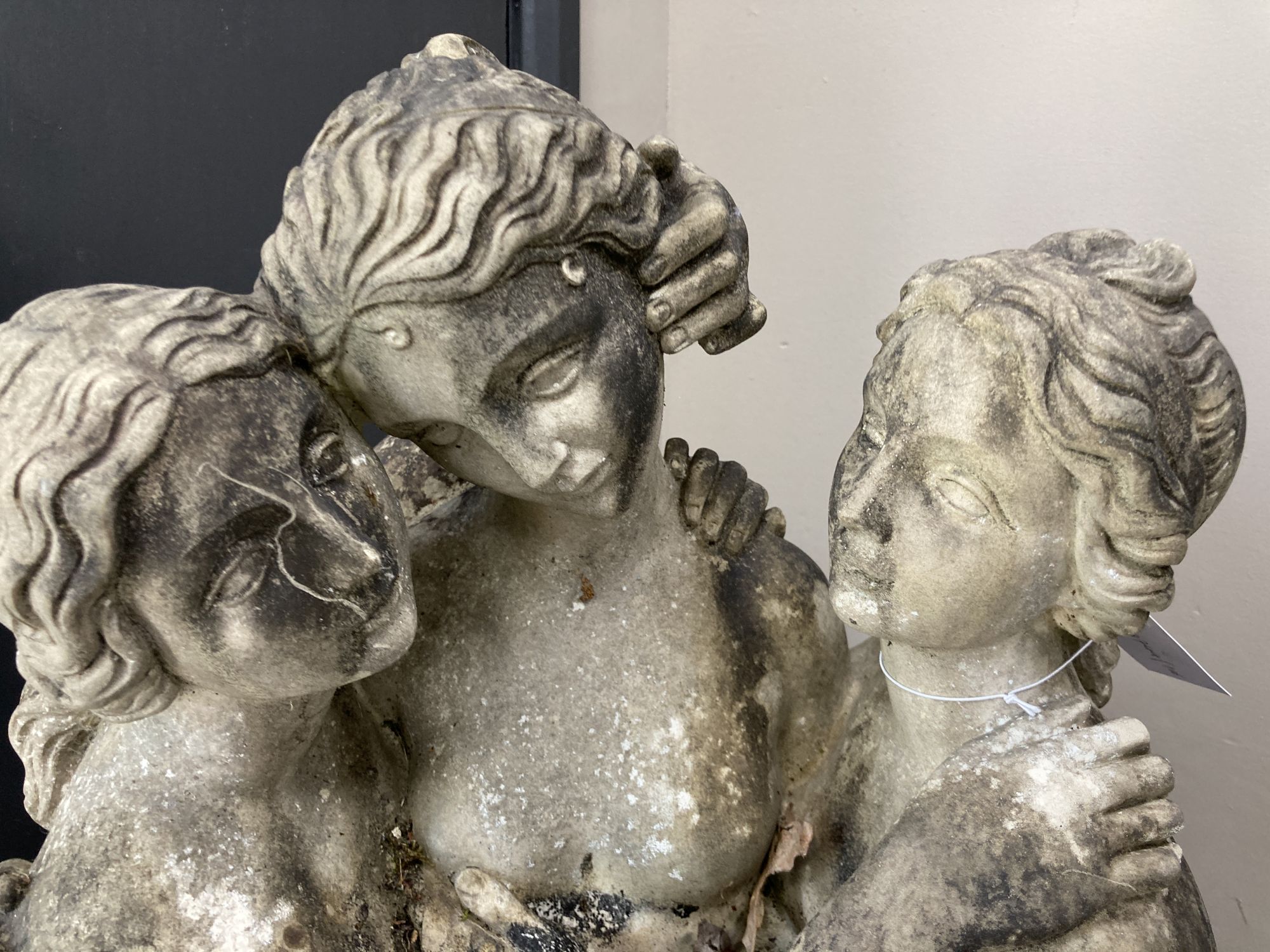 A cast stone garden ornament modelled as the Three Graces, height 106cm